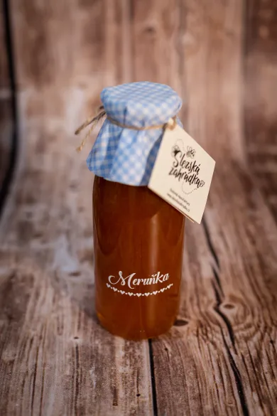 Meruňkový ovocný sirup ve skleněné lahvi s modře kostkovaným víčkem a visačkou Slezská zahrádka