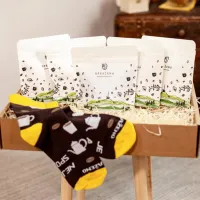 Dárkový balíček čtyři bílé sáčky s motivem kávy krabice se slámou a ponožky černé s žlutými špičkami